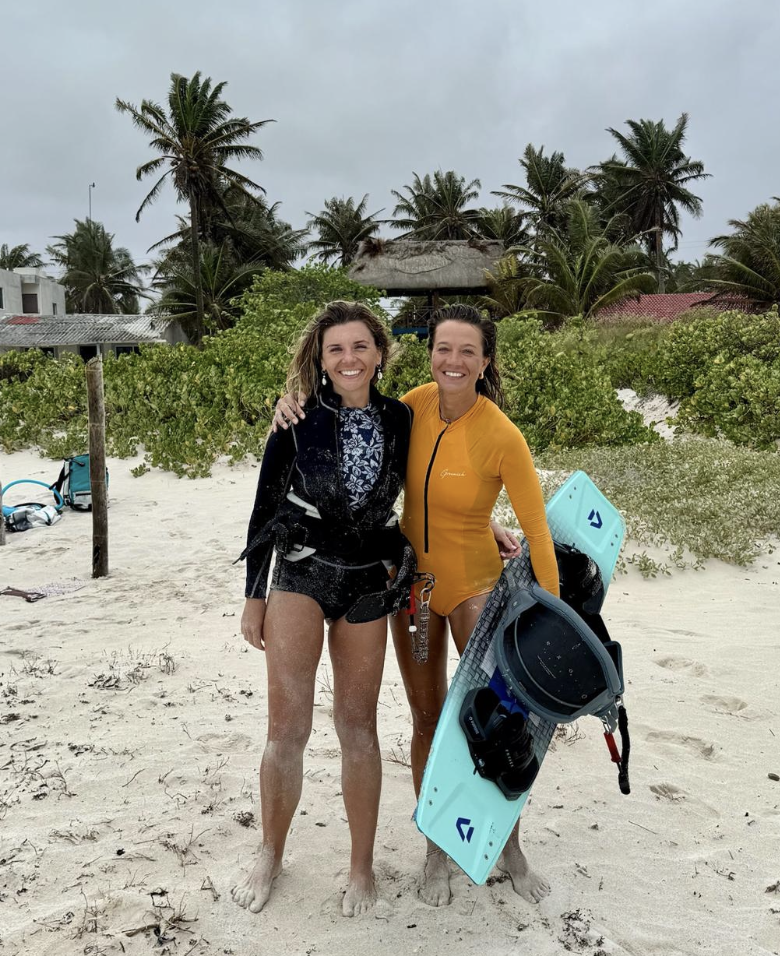 Lydia and Lorena on the beach with their kite gear