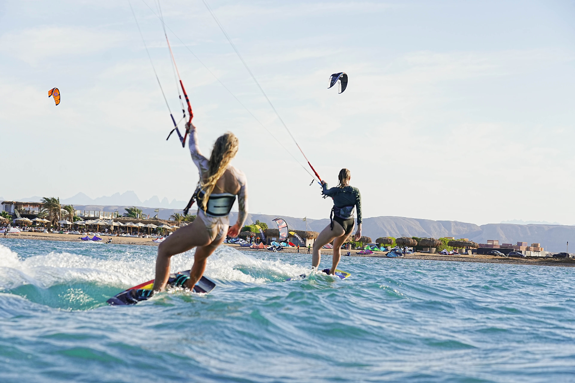 Two kiters riding together across the water