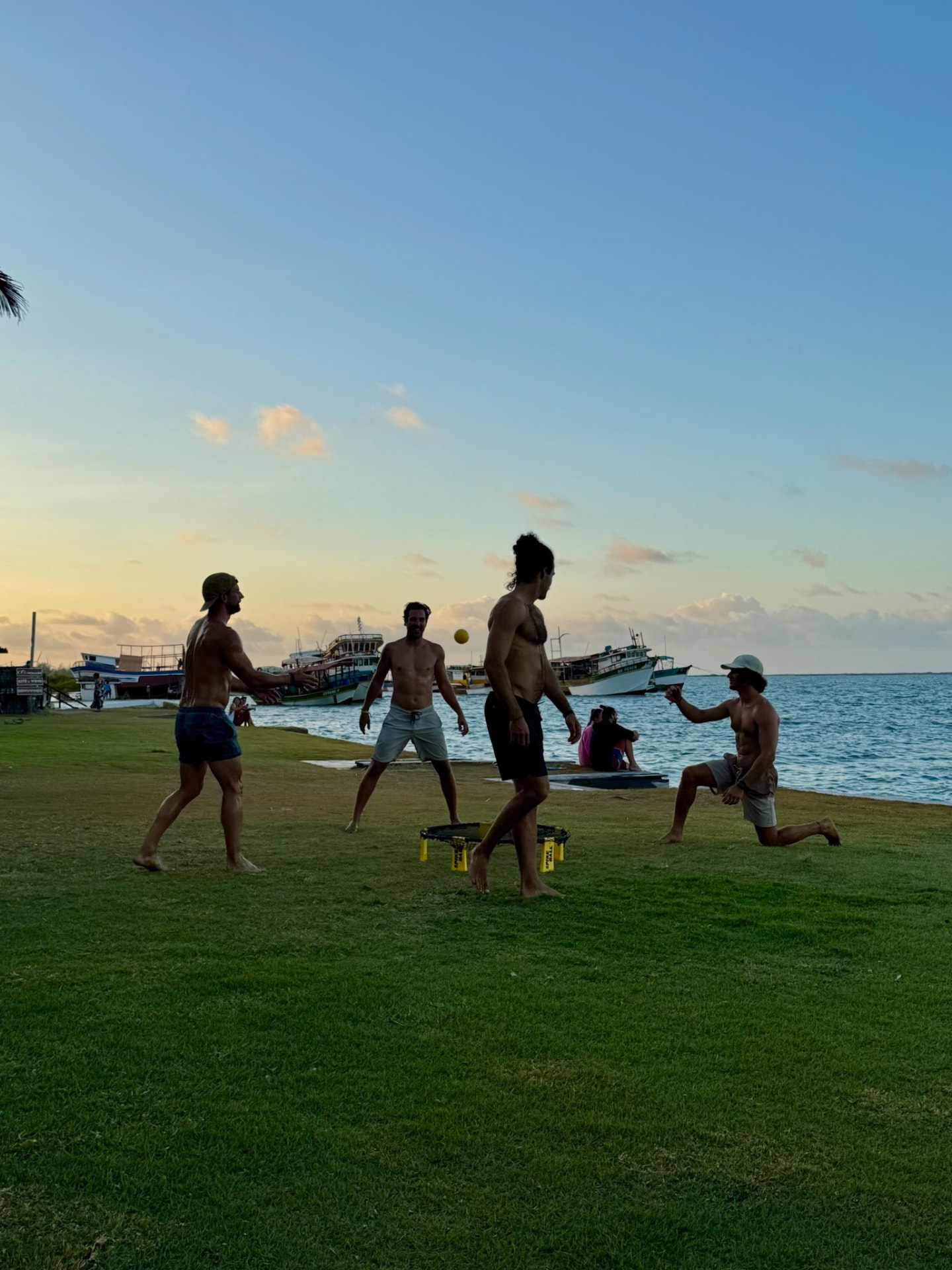 A group of friends playing together by the water at sunset